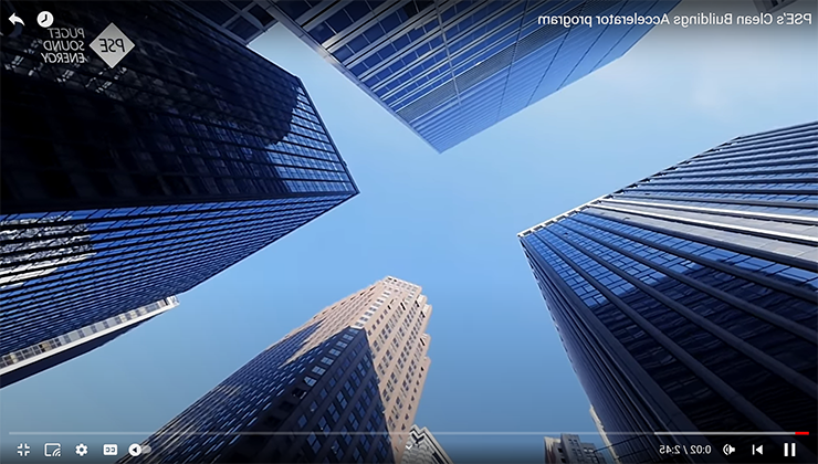 View of blue sky from the ground at the intersection of four tall buildings